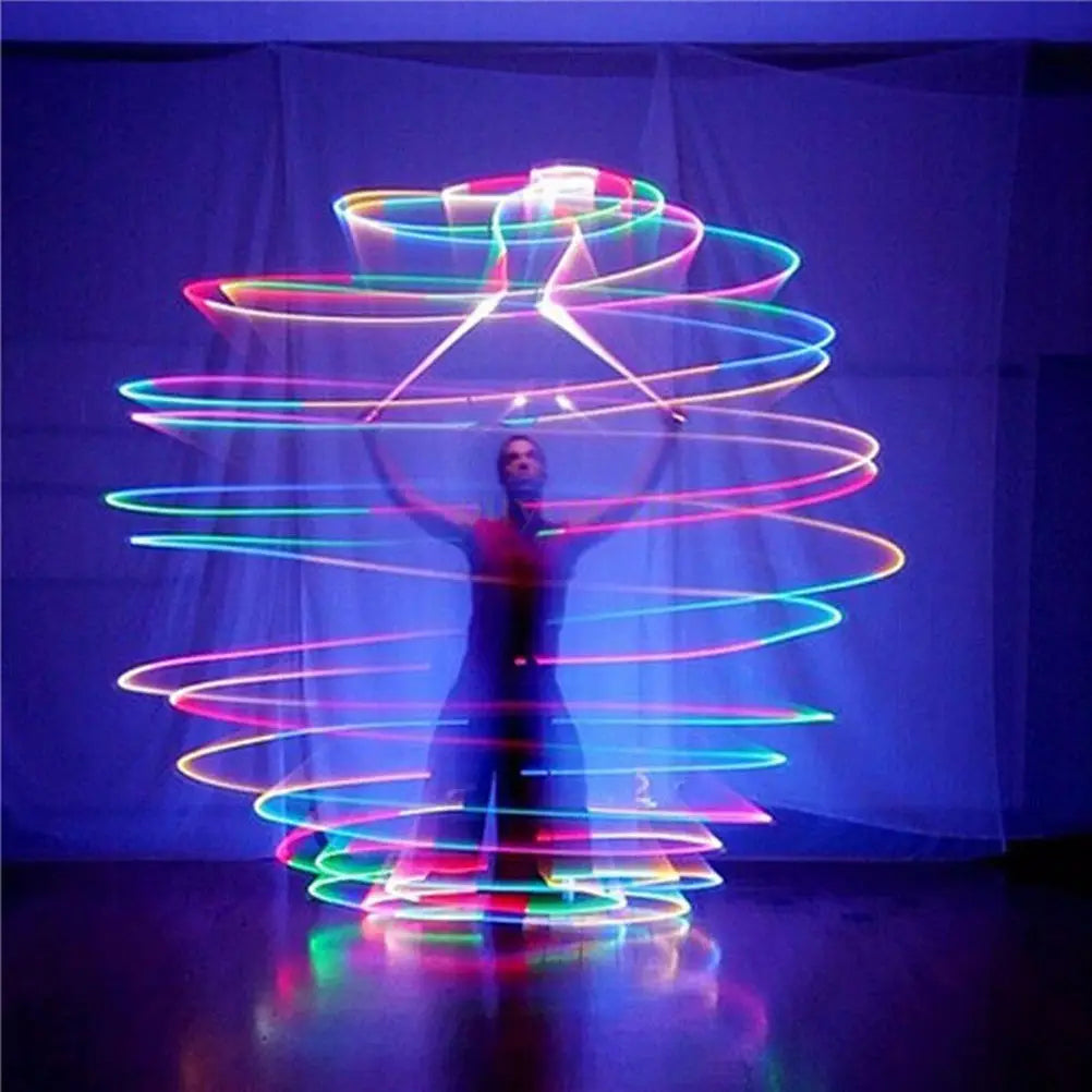 Person spinning glowing LED poi thrown balls in pink, blue, green on dark backdrop