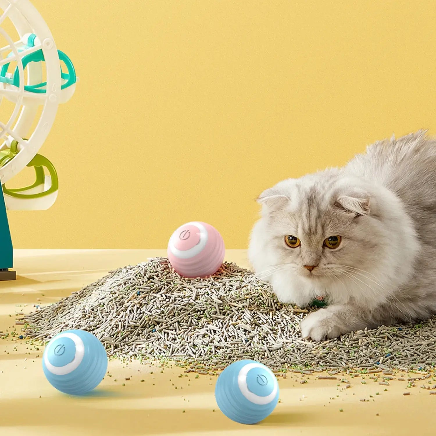 Pink and blue interactive rechargeable cat ball toys on cat litter